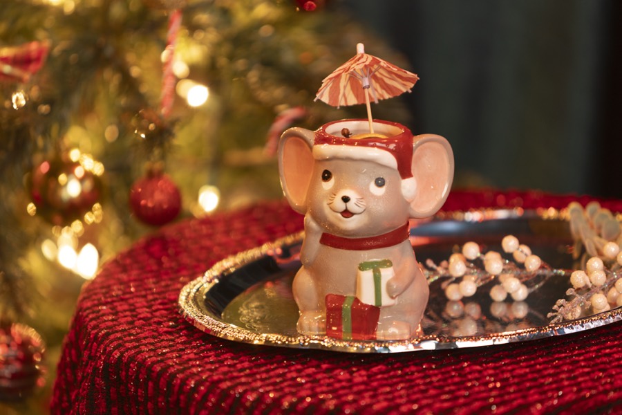 The mouse mug on a silver tray beside a frosted ornament.