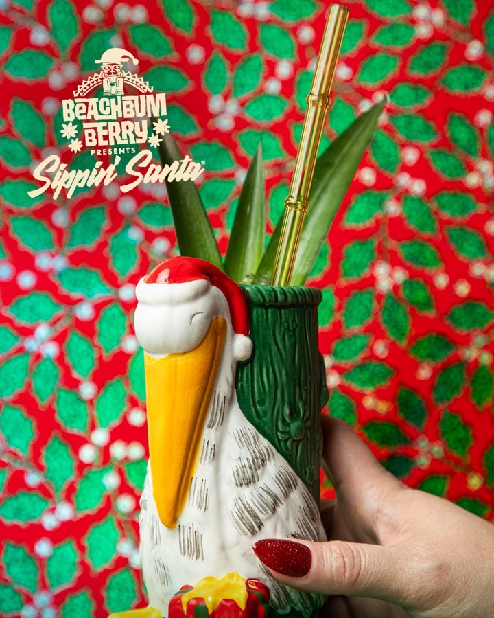 A red-orange tiki cocktail in a Sippin&rsquo; Santa bird mug.